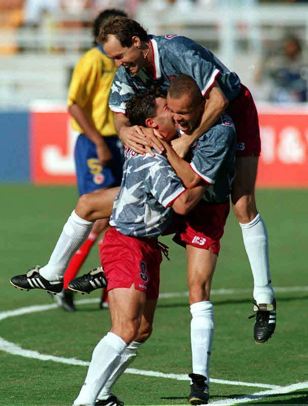 Erneie Stewart mobbed by his teammates after scoring the second goal against Colombia