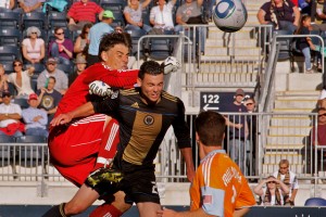Nick Zimmerman fights for a ball with Houston goalie Pat Onstad. (Photo: Paul Rudderow)