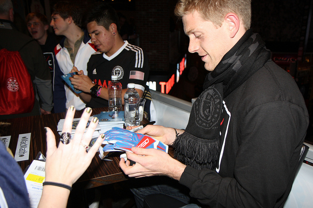 Zac MacMath signs a couple of gloves